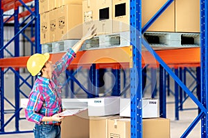 Senior Asian Manager in Hardhat Working in a Hardware Warehouse Standing Checking Supplies