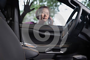 Senior asian woman forgot her key inside locked car