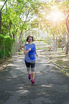 Senior asian woman happy jogging running in the park