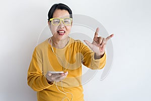 Senior Asian woman listening to music with earphone,Elderly female using smartphone feeling funny and enjoying,Relaxing time,Happy