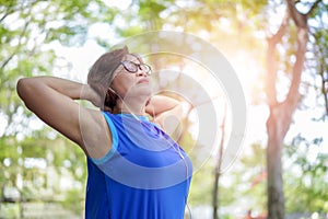 Senior asian woman relaxed listening to music in the park