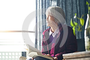 Senior asian woman sitting & reading book enjoying retirments