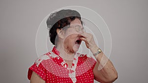 Senior Asian woman stuffy nose from air allergy and a lot of dust, A senior woman blowing her nose. old lady got cold or flu,