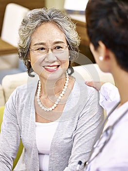 Senior asian woman talking to a medical worker