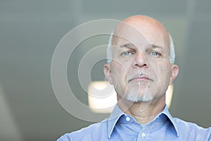 Senior balding man with a deadpan expression photo