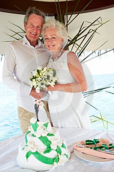 Senior Beach Wedding Ceremony With Cake In Foreground