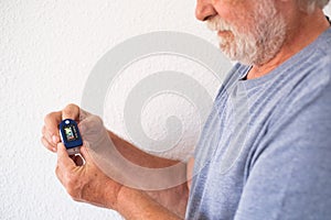 Senior bearded man shows how to measure oxygen saturation level in blood with digital oximeter device