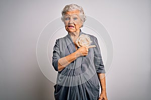 Senior beautiful grey-haired woman wearing casual dress standing over white background Pointing aside worried and nervous with