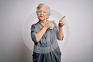 Senior beautiful grey-haired woman wearing casual dress standing over white background Pointing aside worried and nervous with