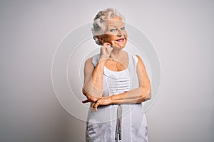 Senior beautiful grey-haired woman wearing casual summer dress over white background looking confident at the camera with smile