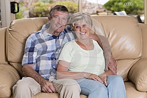 Senior beautiful middle age couple around 70 years old smiling happy together at home living room sofa couch looking sweet in life