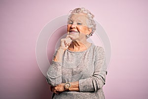 Senior beautiful woman wearing casual t-shirt standing over isolated pink background looking confident at the camera smiling with