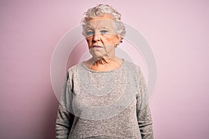 Senior beautiful woman wearing casual t-shirt standing over isolated pink background looking sleepy and tired, exhausted for