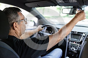 Senior behind the steering wheel looking at map for directions