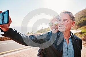 Senior biker couple, road trip selfie and smile with sunglasses, love and romance on vacation in nature. Elderly lady
