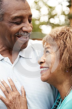 Senior African American  husband and wife embracing, close up, vertical