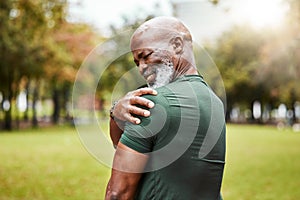 Senior black man with shoulder pain, fitness injury and exercise in the park with muscle ache or inflammation outdoor