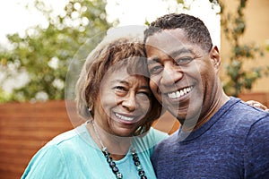 Senior African American  woman and her middle aged son smiling to camera, head and shoulders, close up