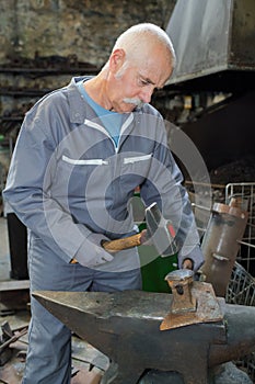 Senior blacksmith in production process metal products