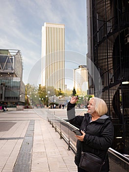 senior blonde business woman looks at her glasses photo