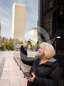 senior blonde business woman looks at her glasses photo