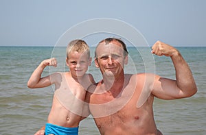 Senior and boy show bicepses