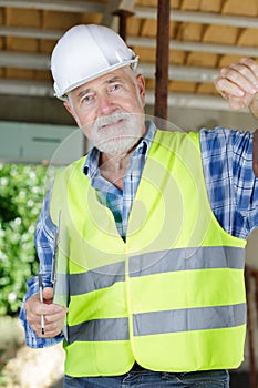 senior builder in helmet looking at camera