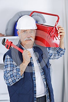 Senior builder holding red tool box