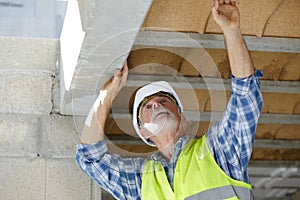 Senior builder installing wall