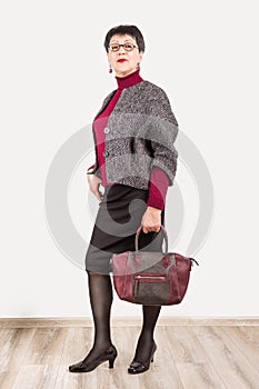 Senior buisness woman standing isolated on grey studio background photo