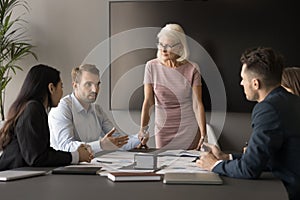 Senior business group leader woman standing at meeting table