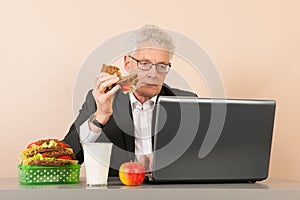 Senior business man eating bread