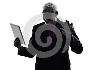 Senior business man holding digital tablet saluting silhouette