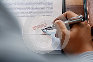 Senior business man male hand putting or signing signature in the certificate contract after approve stamp on loan document