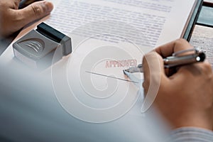Senior business man male hand putting or signing signature in the certificate contract after approve stamp on loan document