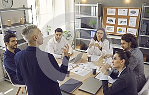 Senior business man manager gives instructions to his subordinates at a meeting in a modern office.