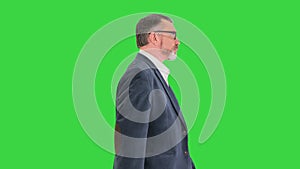 Senior business man walking forward on a Green Screen, Chroma Key.