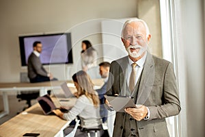 Senior business man workin on digital tablet in the office