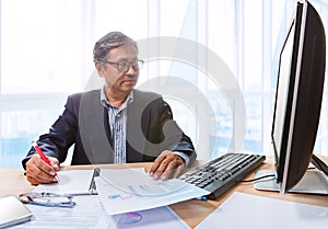 Senior business man working on office tabel with computer and bu