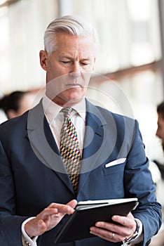 Senior business man working on tablet computer