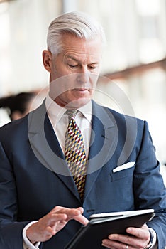 Senior business man working on tablet computer
