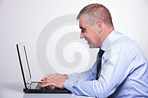 Senior business man writes on laptop