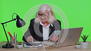 Senior business office woman accountant or banker making money cash calculations, income, earnings