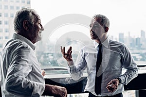 Senior Business People Talk about the Concept Project during a Break while Smoking on the Balcony