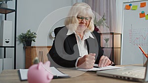 Senior business woman analysing paperwork documents loses, bad fortune, loss, deadline, problem