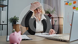 Senior business woman analysing paperwork documents loses, bad fortune, loss, deadline, problem