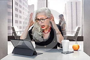 Senior business woman with stress, anxiety, overloaded on computer at the office