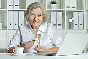 Senior business woman working in office with laptop