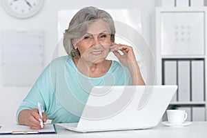 Senior business woman working in office with laptop