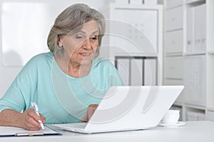 Senior business woman working in office with laptop